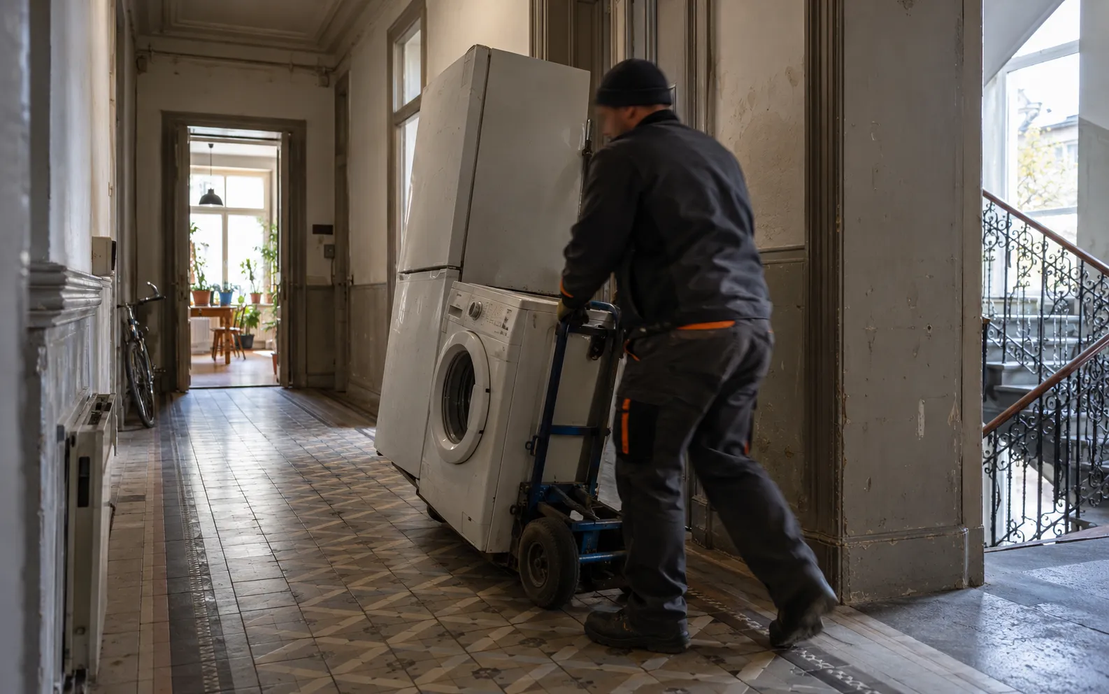 Mitarbeiter transportieren eine Waschmaschine mit einer Sackkarre