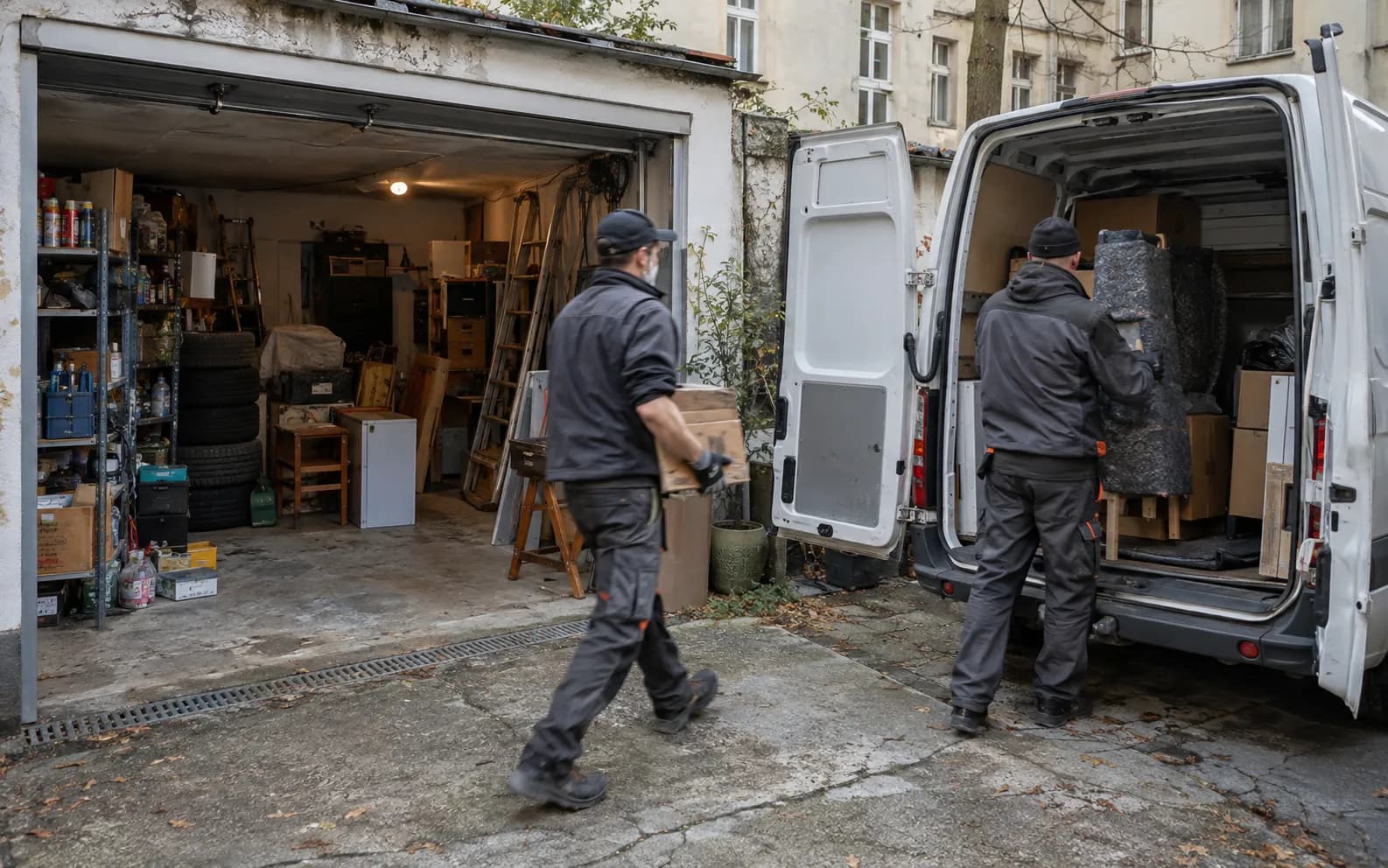 Mitarbeiter räumen eine vollgestellte Garage