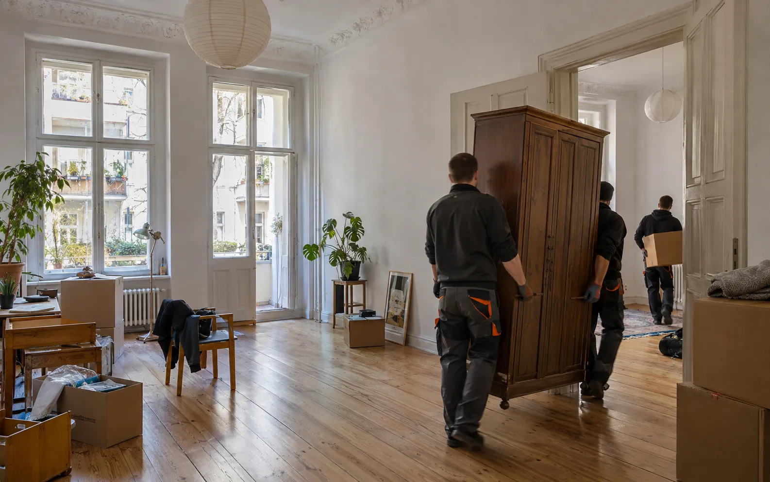 Mitarbeiter tragen Möbel aus einer Wohnung, die für die Übergabe geräumt wird